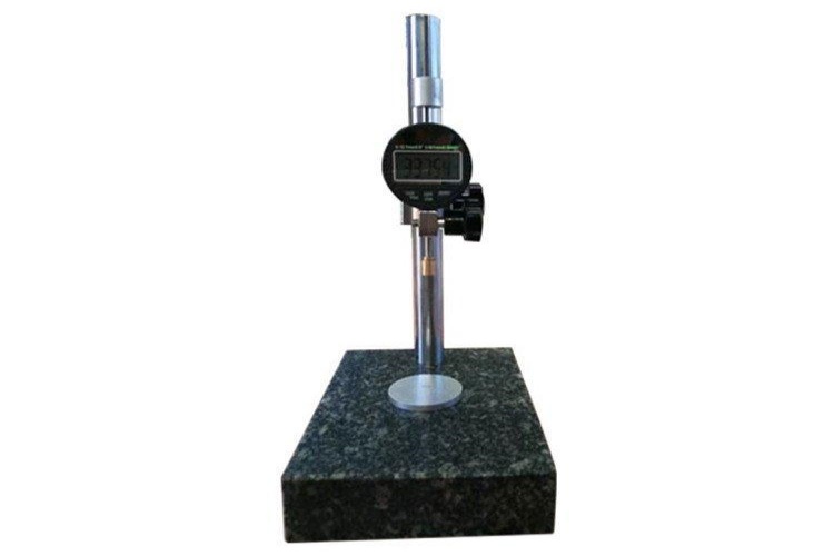 Contractor measuring the thickness of a textured geomembrane with a digital caliper on a construction site