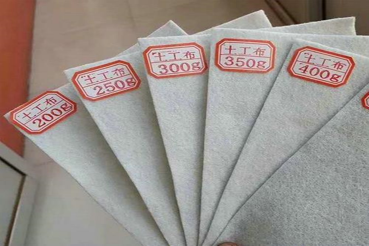 Three samples of nonwoven geotextile fabric side-by-side, showing light, medium, and heavy thicknesses