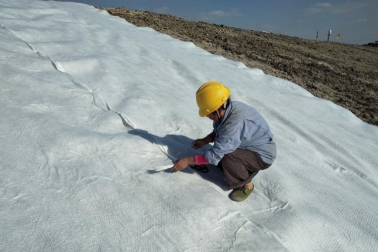 A close-up view of a properly sewn seam connecting two panels of woven geotextile