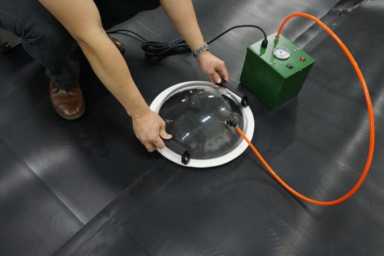 A technician performing air channel pressure testing on a dual-track seam to verify weld integrity