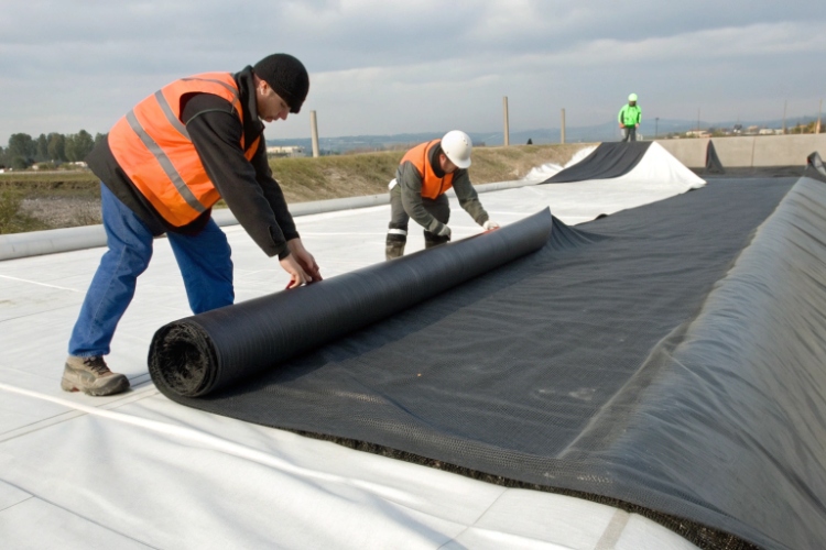 A picture showing a geomembrane-lined pond where one section is covered with soil and the other is exposed to the sun