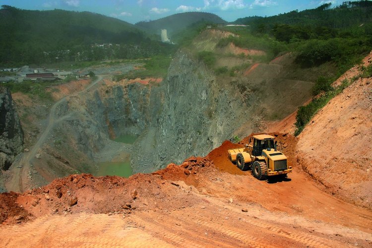 Engineers reviewing design plans and financial projections for a heap leach pad construction project.