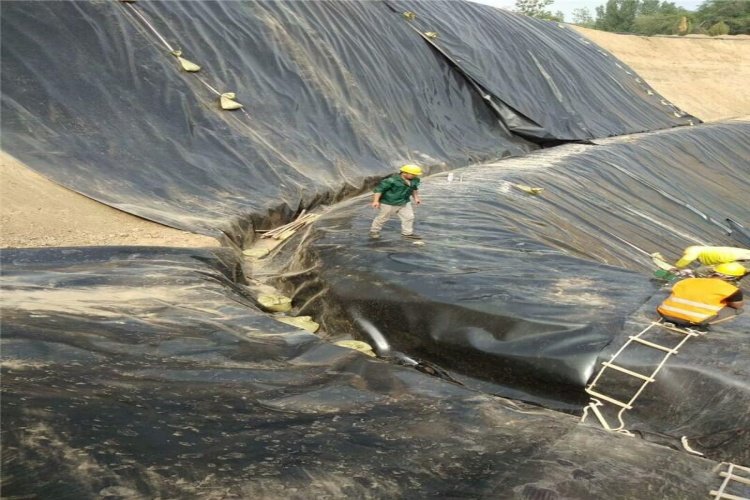 Rolls of black HDPE geomembrane ready for installation at a landfill site