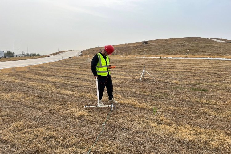 A cross-section diagram illustrating the electrical principle of leak detection in a landfill