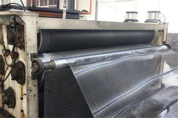 A photograph of a geogrid roll on a job site with a clearly visible tag showing the product type, lot number, and other traceability information.