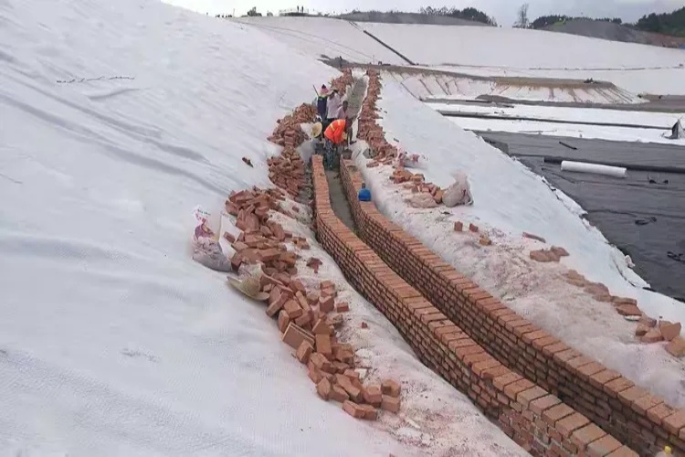 A detailed cross-section diagram of a standard landfill anchor trench showing dimensions, setback, and liner placement