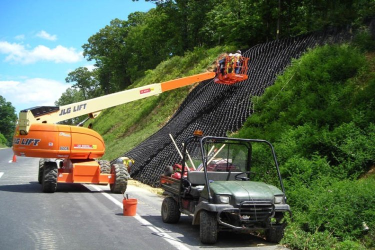 An expanded geocell panel anchored and ready for infill on a construction site
