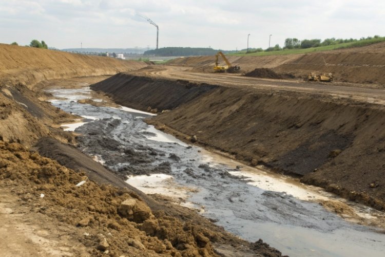 A cross-section diagram showing a contamination plume spreading from a leaking liner into a groundwater aquifer