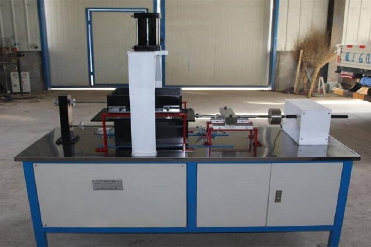 A laboratory technician operating a large-scale direct shear testing device to measure the friction between a geomembrane and a geotextile.