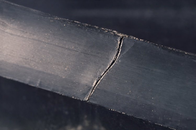 Cross-section diagram showing stress cracking in a geomembrane wrinkle due to thermal cycling