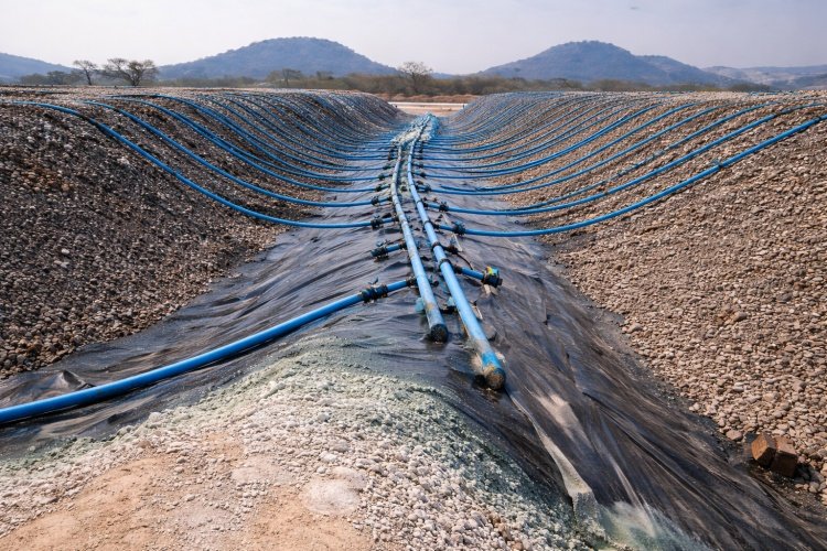 An aerial view of a large-scale heap leach operation, highlighting the critical liner system containing the process solution.