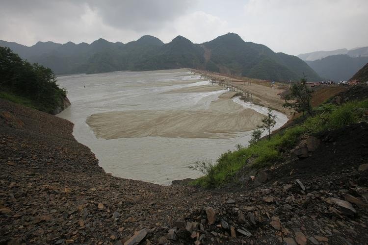 An aerial view of a large, active tailings storage facility showing the embankment, the settled tailings beach, and the supernatant pond