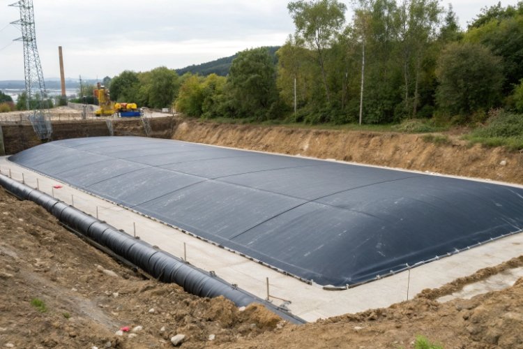 Technician reviewing a technical datasheet with a roll of geomembrane in the background