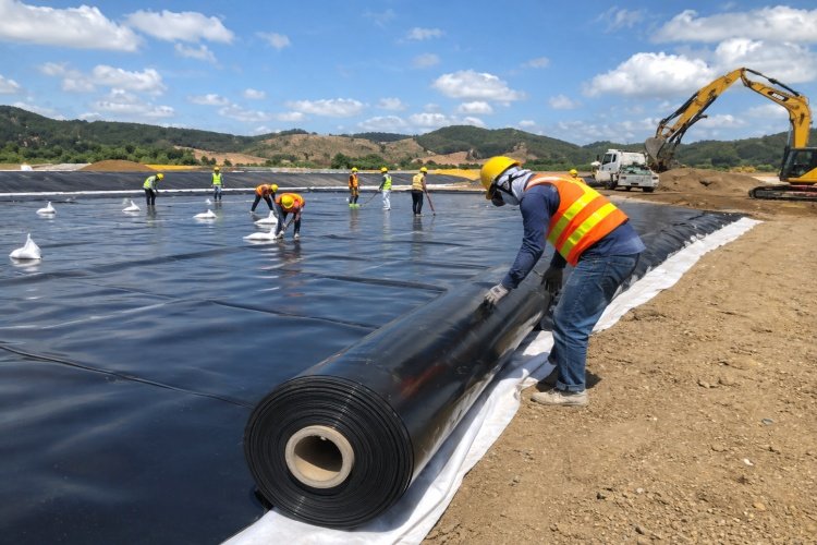 Installers using hot wedge welders to seam HDPE geomembrane panels